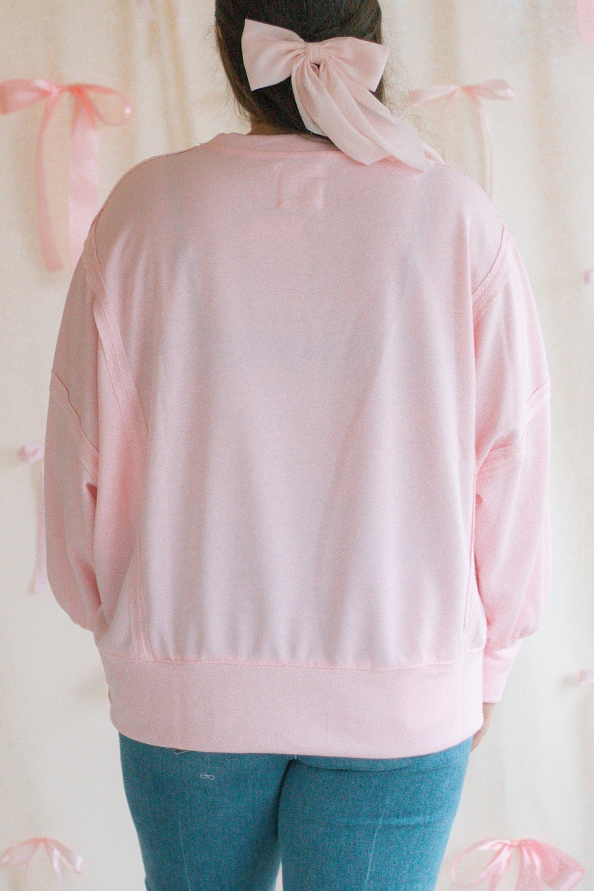 light bubblegum pink Terry cloth pullover with raw hem details, front slits, and red patchwork embroidered love