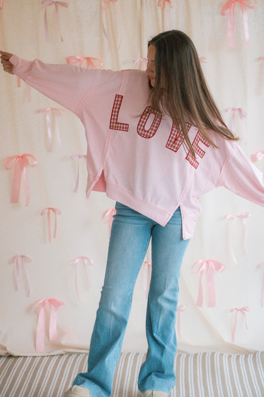light bubblegum pink Terry cloth pullover with raw hem details, front slits, and red patchwork embroidered love