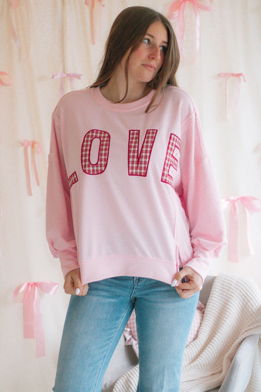 light bubblegum pink Terry cloth pullover with raw hem details, front slits, and red patchwork embroidered love