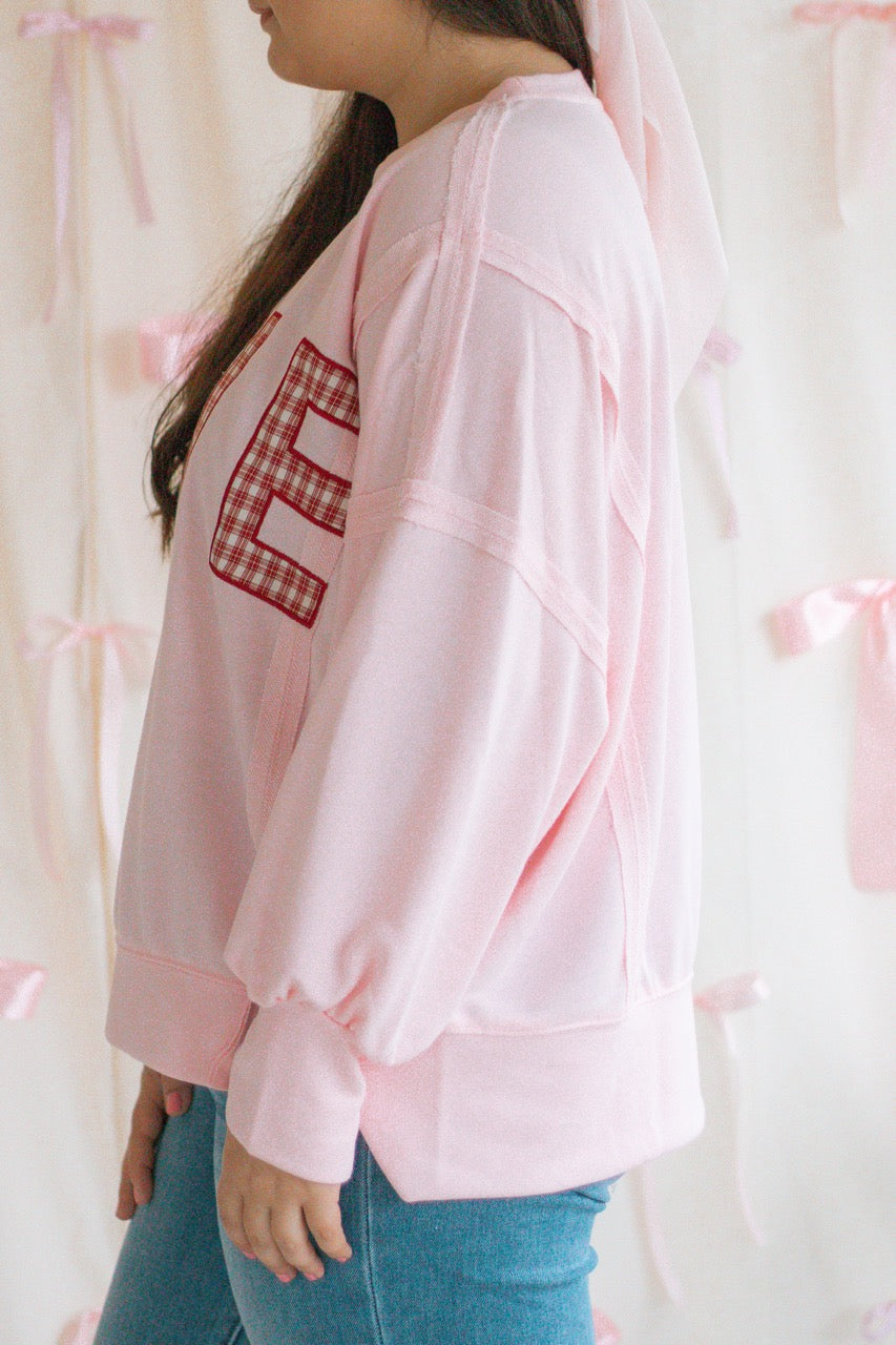 light bubblegum pink Terry cloth pullover with raw hem details, front slits, and red patchwork embroidered love