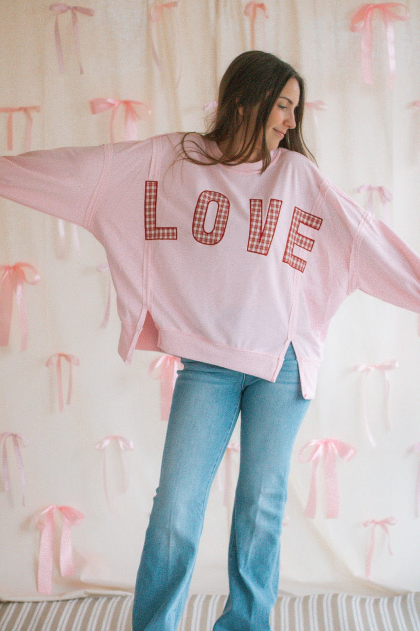 light bubblegum pink Terry cloth pullover with raw hem details, front slits, and red patchwork embroidered love